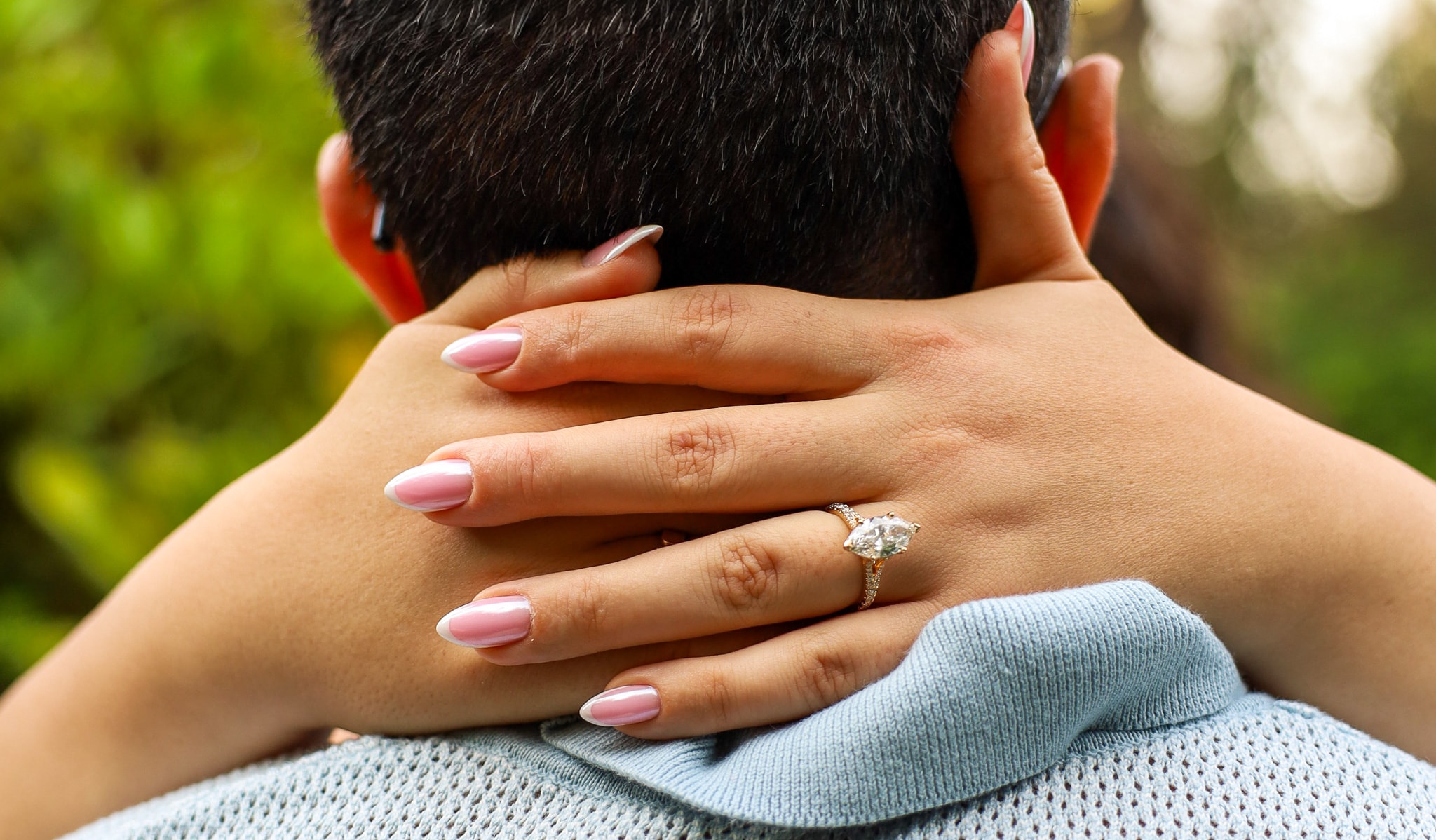 couple displaying engagement ring outdoors